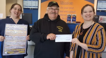 AAACU Team member presents a check to a member of the Cheboygan High School Senior Class of 2025